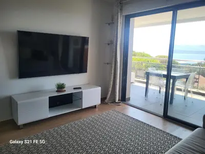 a living room with a flat screen tv on a wall at T2 VUE MER - ENTREE DE VILLE in Ajaccio