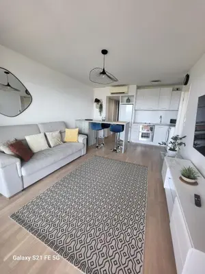 a living room with a couch and a kitchen at T2 VUE MER - ENTREE DE VILLE in Ajaccio