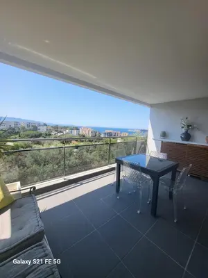 a living room with a table and a large window at T2 VUE MER - ENTREE DE VILLE in Ajaccio