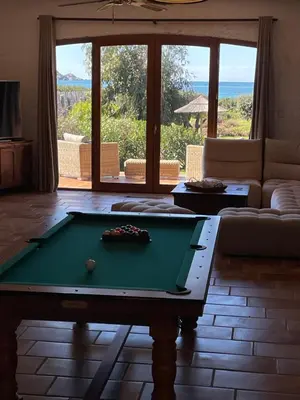 a living room with a pool table and a couch at Villa pieds dans l'eau, Casa d'Omigna, Corse du sud, Cargèse, in Cargèse
