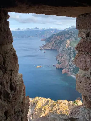 a view of the ocean through a window at Villa pieds dans l'eau, Casa d'Omigna, Corse du sud, Cargèse, in Cargèse