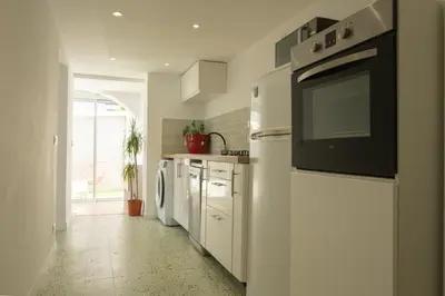 a kitchen with white cabinets and a black appliance at CASA MONICA CARGESE - Swing 42 - appartement in Cargèse