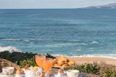 a table with a plate of food on the beach at Boutique hôtel Château Rouher in Propriano
