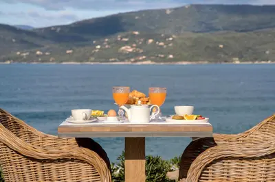 a table with a tray of food and orange juice at Boutique hôtel Château Rouher in Propriano