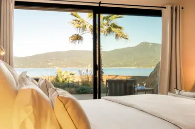a bedroom with a view of the ocean at Boutique hôtel Château Rouher in Propriano