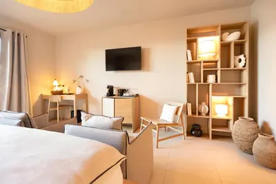 a hotel room with a bed and a tv at Boutique hôtel Château Rouher in Propriano