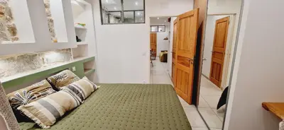 a hallway with a couch with a green rug at Appartement plein de charme - Ajaccio hyper centre in Ajaccio
