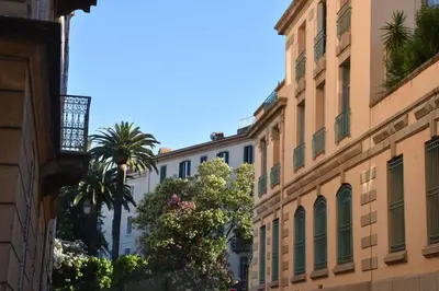 a city street with buildings and palm trees at Appartement plein de charme - Ajaccio hyper centre in Ajaccio