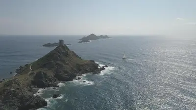 an island with a sail boat in the ocean at Appartement plein de charme - Ajaccio hyper centre in Ajaccio