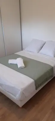a bed with white sheets and a towel on it at Casa Prunelli in Omessa