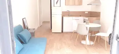 a small kitchen with a table and a white table and chairs at Casa Prunelli in Omessa