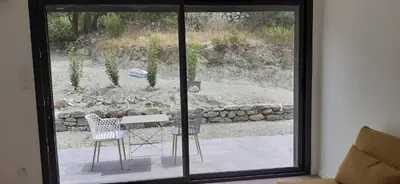 a room with a sliding glass door with a table and chairs at Casa Prunelli in Omessa