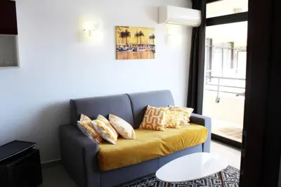 a blue couch with pillows on it in a room at CosySeaside Corsica Ajaccio Piscine Terrasse Mer in Ajaccio