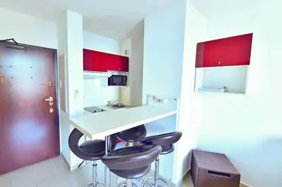 a kitchen with two bar stools and a counter at CosySeaside Corsica Ajaccio Piscine Terrasse Mer in Ajaccio