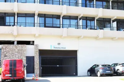 a white building with cars parked in front of it at CosySeaside Corsica Ajaccio Piscine Terrasse Mer in Ajaccio