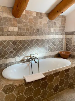 a bath tub with a towel on the side of it at Chambres d'hôtes et studios de charme - A Mandria in Murato