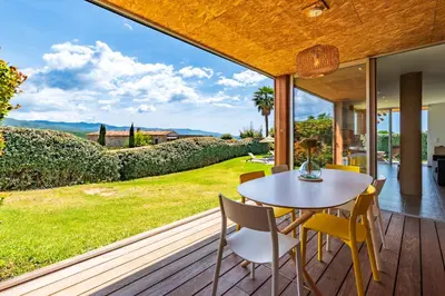 a dining room with a table and chairs on a deck at Splendide appartement T3 piscine et vue mer in Grosseto-Prugna
