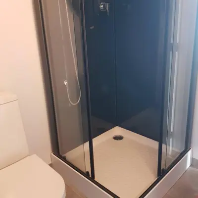 a shower with a glass door next to a toilet at Splendide appartement T3 piscine et vue mer in Grosseto-Prugna