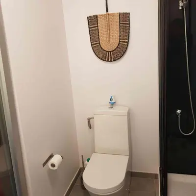 a bathroom with a toilet and a basket on the wall at Splendide appartement T3 piscine et vue mer in Grosseto-Prugna