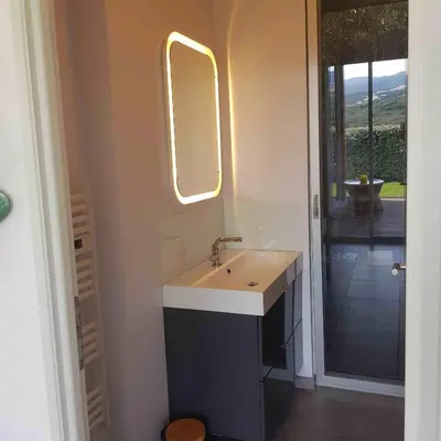 a bathroom with a sink and a mirror at Splendide appartement T3 piscine et vue mer in Grosseto-Prugna