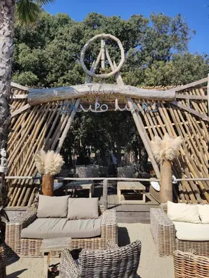 a wooden arch with wicker chairs and a sign at Studio 4 personnes bord de mer avec piscine wifi in Cervione