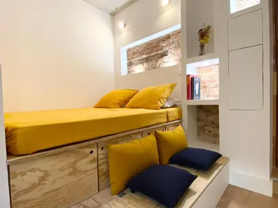 a room with two beds with yellow cushions at Studio d'architecte centre historique in Ajaccio