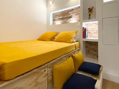 a bed with yellow pillows on top of it at Studio d'architecte centre historique in Ajaccio