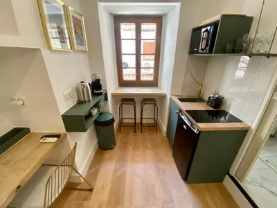 a small kitchen with green cabinets and a window at Studio d'architecte centre historique in Ajaccio