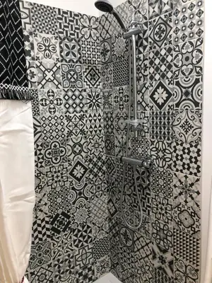 a shower in a bathroom with black and white tiles at Muratello Appart 1 in Porto-Vecchio