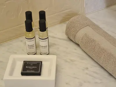two bottles ofodorizers on a counter next to a towel at Les Terrasses de Sari in Sari Solenzara