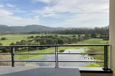 a balcony with a view of a river and mountains at Appartement magnifique - Luxe - Proche du port - 1 chambre - Pour des vacances paisibles in Porto-Vecchio