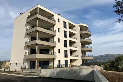 a white building with balconies on the side of it at Appartement magnifique - Luxe - Proche du port - 1 chambre - Pour des vacances paisibles in Porto-Vecchio