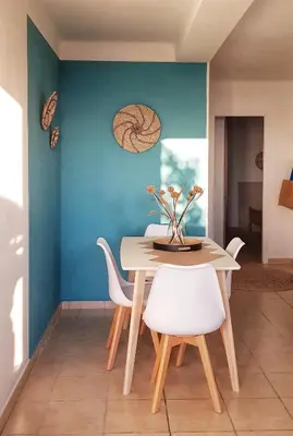 a dining room with a table and white chairs at Appartement T2bis Sartène 60m2 avec jolie terrasse de 25m2 et vue panoramique mer et montagne sur le Golfe du Valinco - Quartier calme à 10mn à pied du centre ville - Idéal pour 4 personnes et possibilité de 6 couchages - Place de parking réservée in Sartène