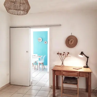 a room with a desk and a table with a lamp at Appartement T2bis Sartène 60m2 avec jolie terrasse de 25m2 et vue panoramique mer et montagne sur le Golfe du Valinco - Quartier calme à 10mn à pied du centre ville - Idéal pour 4 personnes et possibilité de 6 couchages - Place de parking réservée in Sartène
