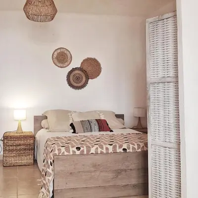 a bedroom with a bed and two baskets on the wall at Appartement T2bis Sartène 60m2 avec jolie terrasse de 25m2 et vue panoramique mer et montagne sur le Golfe du Valinco - Quartier calme à 10mn à pied du centre ville - Idéal pour 4 personnes et possibilité de 6 couchages - Place de parking réservée in Sartène