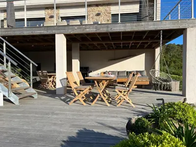 a wooden table and chairs on a patio at Villa Pura Corsica with sea view and private pool in Conca