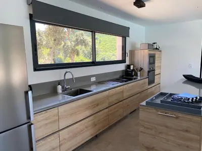 a kitchen with a sink and a large window at Villa Pura Corsica with sea view and private pool in Conca