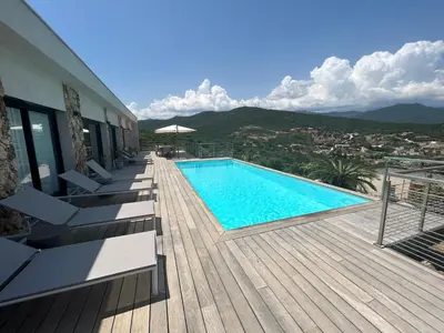 a swimming pool on a deck next to a building at Villa Pura Corsica with sea view and private pool in Conca