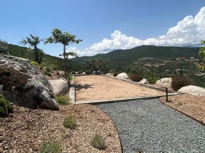 a walkway with a mountain in the background at Villa Pura Corsica with sea view and private pool in Conca