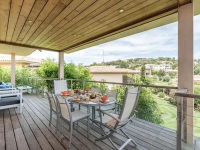 a patio with a table and chairs on a deck at Apartment Côté Plage by Interhome in Sainte-Lucie de Porto-Vecchio