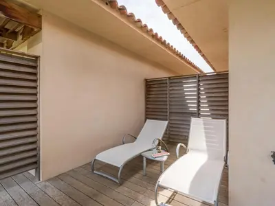 a balcony with two white chairs and a table at Apartment Côté Plage by Interhome in Sainte-Lucie de Porto-Vecchio