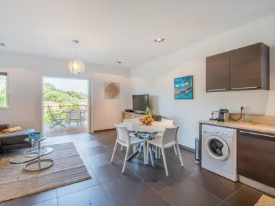 a kitchen and living room with a table and a laundry machine at Apartment Côté Plage by Interhome in Sainte-Lucie de Porto-Vecchio