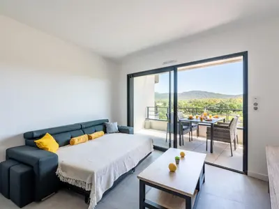 a bedroom with a bed and a couch and a table at Apartment Stanatura-3 by Interhome in Porto-Vecchio