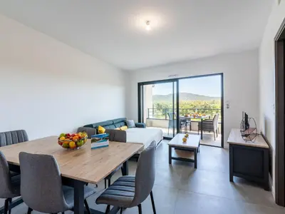 a living room with a table and a couch at Apartment Stanatura-3 by Interhome in Porto-Vecchio