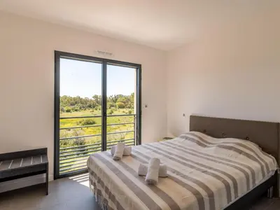 a bedroom with a bed and a large window at Apartment Stanatura-3 by Interhome in Porto-Vecchio
