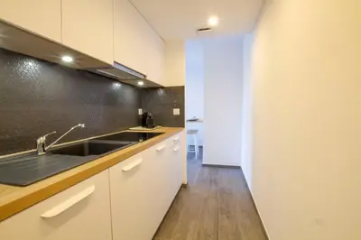 a kitchen with white cabinets and a sink at STUDIO PORTICCIO AGOSTA PLAGE in Porticcio