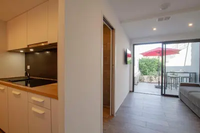 a kitchen and living room with a view of a patio at STUDIO PORTICCIO AGOSTA PLAGE in Porticcio