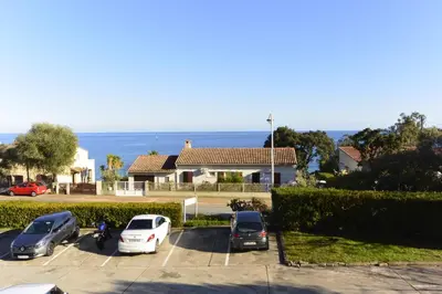 a parking lot with cars parked in front of a house at CYSTES in Kamiesch