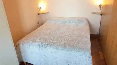 a small bedroom with a white bed in a room at CYSTES in Kamiesch