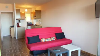 a red couch in a living room with a table at CYSTES in Kamiesch